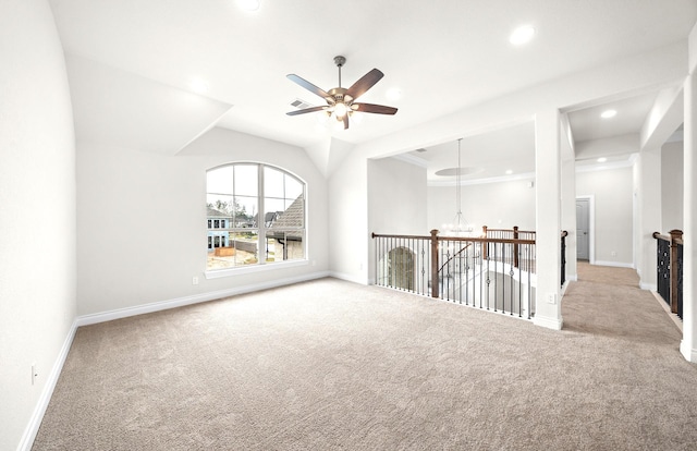 spare room featuring ceiling fan with notable chandelier and light carpet