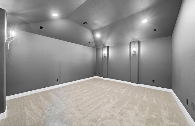 cinema room with carpet and vaulted ceiling