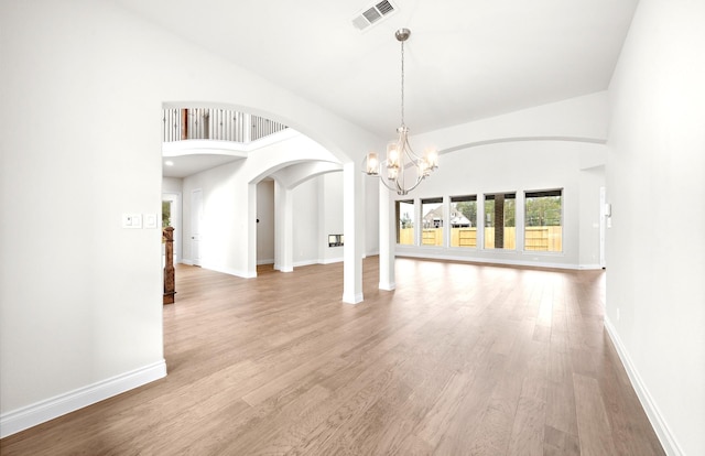 interior space with hardwood / wood-style floors, a towering ceiling, and an inviting chandelier