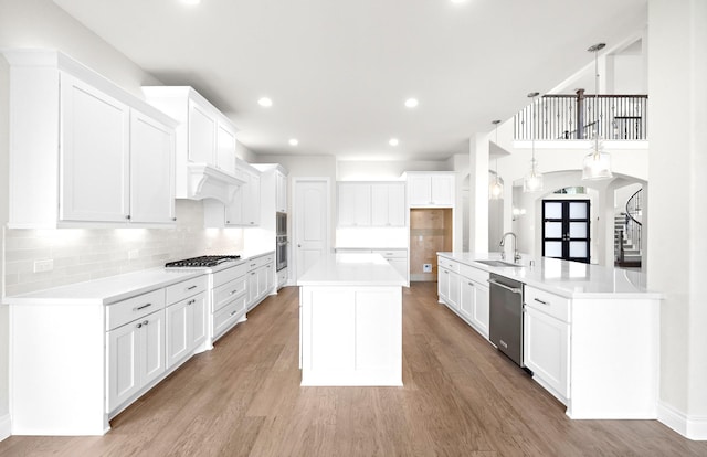 kitchen featuring white cabinets, light wood-type flooring, and stainless steel appliances