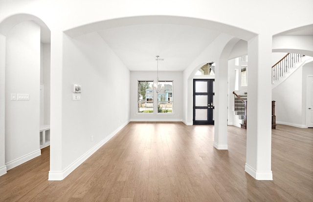 unfurnished living room with hardwood / wood-style floors and a notable chandelier