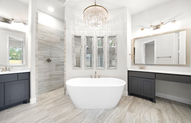 bathroom with a bathtub, vanity, and a notable chandelier