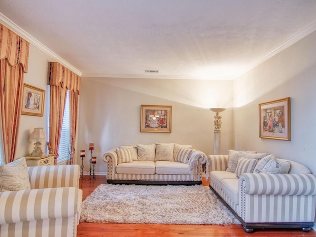 living room with wood-type flooring, vaulted ceiling, and ornamental molding