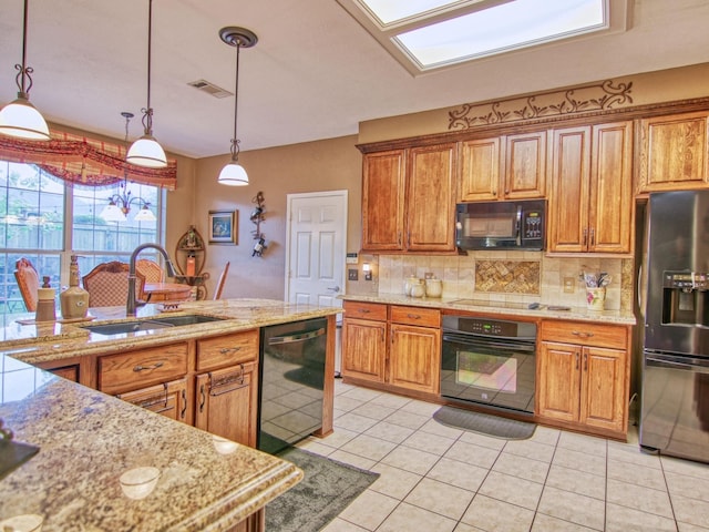 kitchen with light tile patterned flooring, sink, hanging light fixtures, and black appliances