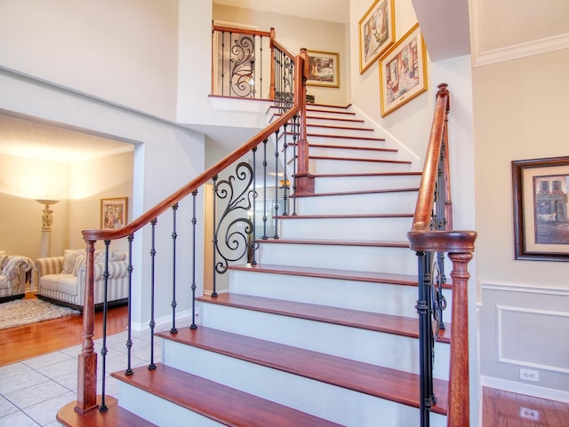 stairway featuring hardwood / wood-style floors and ornamental molding