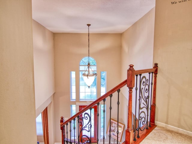 staircase with hardwood / wood-style flooring and a chandelier