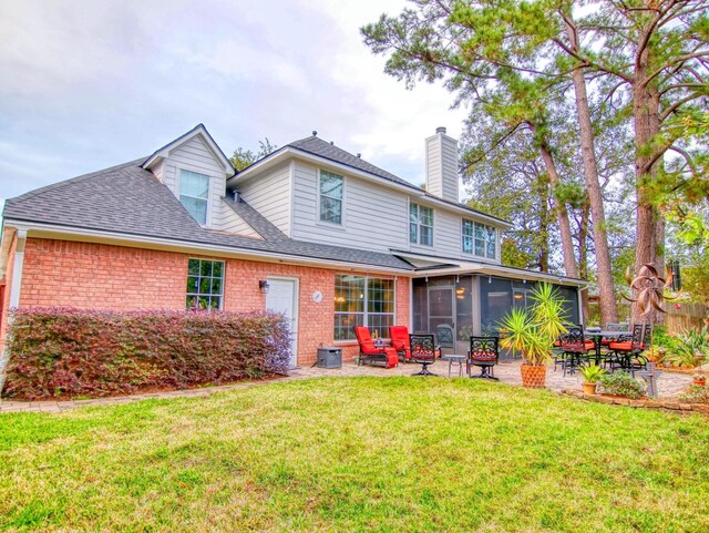 rear view of property featuring a sunroom, a patio area, and a yard