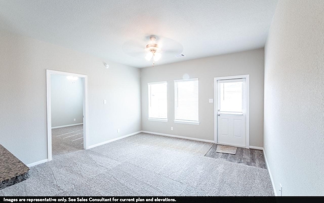 spare room with ceiling fan, light colored carpet, and a textured ceiling