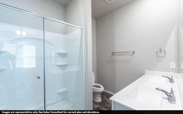 bathroom featuring a shower, wood-type flooring, vanity, and toilet