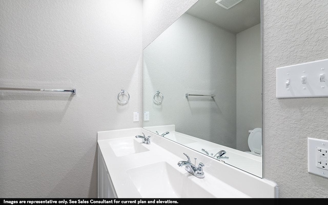 bathroom featuring vanity and toilet