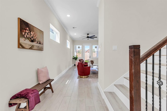 hallway with ornamental molding and light hardwood / wood-style flooring