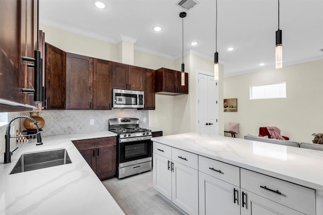 kitchen featuring sink, crown molding, light stone countertops, decorative light fixtures, and stainless steel appliances