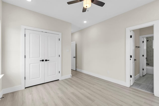 unfurnished bedroom with ceiling fan, ensuite bathroom, light hardwood / wood-style flooring, and a closet