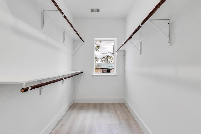 spacious closet with light hardwood / wood-style flooring