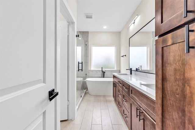 bathroom with vanity and shower with separate bathtub