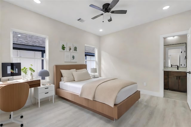 bedroom featuring light wood-type flooring, ensuite bath, and ceiling fan