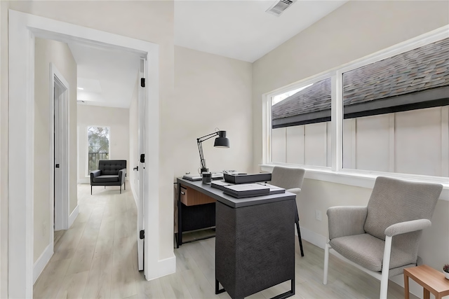 home office with light hardwood / wood-style flooring