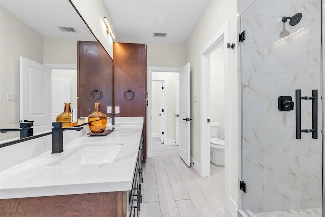 bathroom featuring wood-type flooring, vanity, toilet, and a shower with door