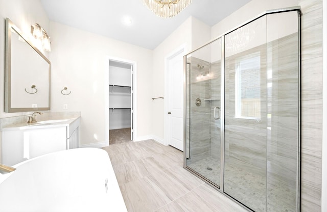 bathroom with tile patterned flooring, vanity, independent shower and bath, and an inviting chandelier