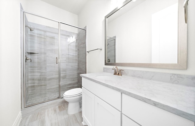 bathroom with an enclosed shower, vanity, and toilet