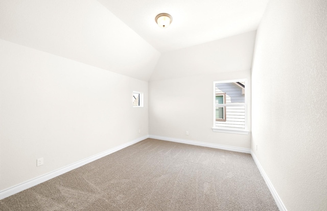 empty room with carpet floors and lofted ceiling