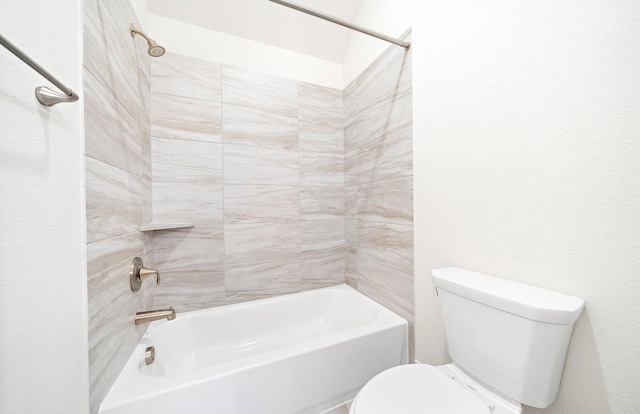 bathroom featuring tiled shower / bath combo and toilet