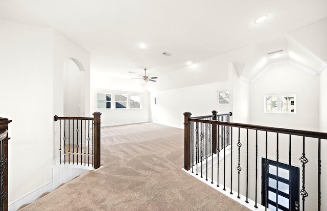 corridor featuring light colored carpet and vaulted ceiling