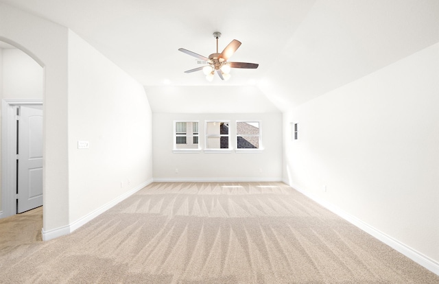 carpeted empty room featuring ceiling fan and vaulted ceiling