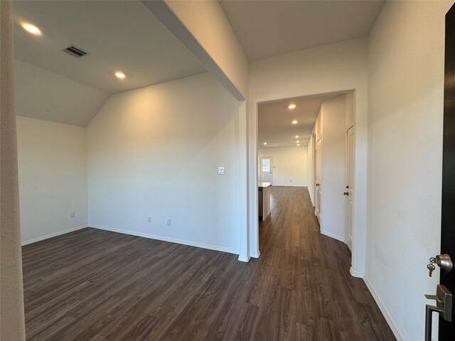 unfurnished room with dark hardwood / wood-style flooring and lofted ceiling