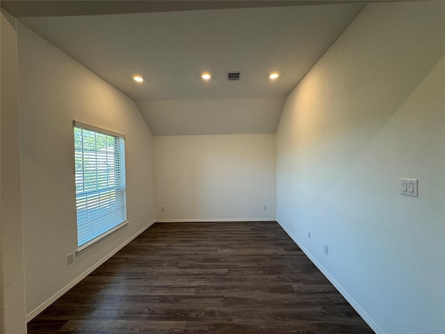 empty room featuring dark hardwood / wood-style flooring and vaulted ceiling