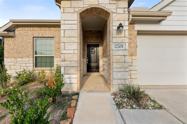 12305 Delta Timber Rd, Conroe, TX 77304 - entrance to property featuring an attached garage, stone siding, brick siding, and concrete driveway