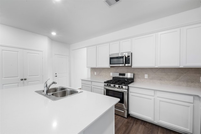 12305 Delta Timber Rd, Conroe, TX 77304 - kitchen with stainless steel appliances, a sink, white cabinetry, and recessed lighting