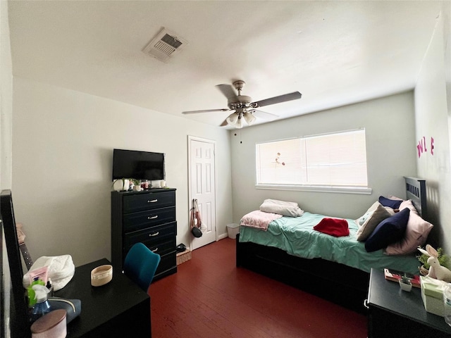 bedroom featuring ceiling fan, dark wood-type flooring, and a closet