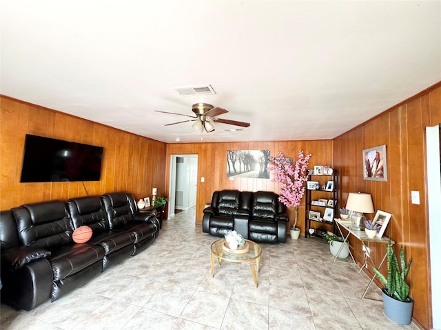 living room featuring ceiling fan and wooden walls