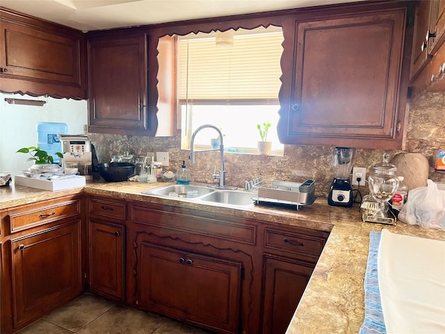 kitchen featuring backsplash, sink, and light tile patterned floors