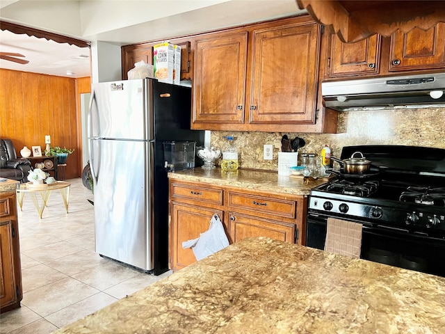 kitchen featuring decorative backsplash, ceiling fan, light tile patterned floors, black range with gas cooktop, and stainless steel refrigerator