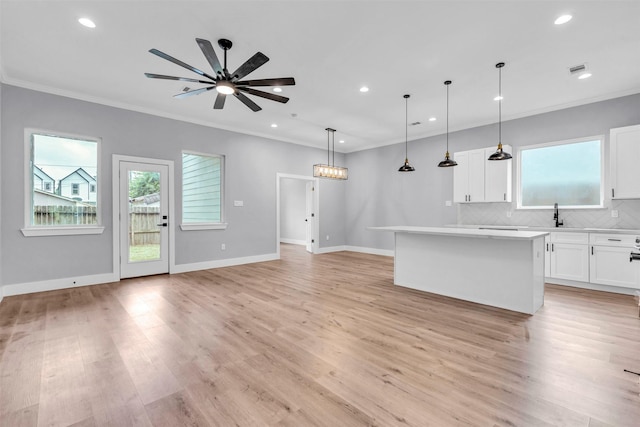 kitchen featuring a kitchen island, ceiling fan, decorative light fixtures, light hardwood / wood-style flooring, and white cabinetry