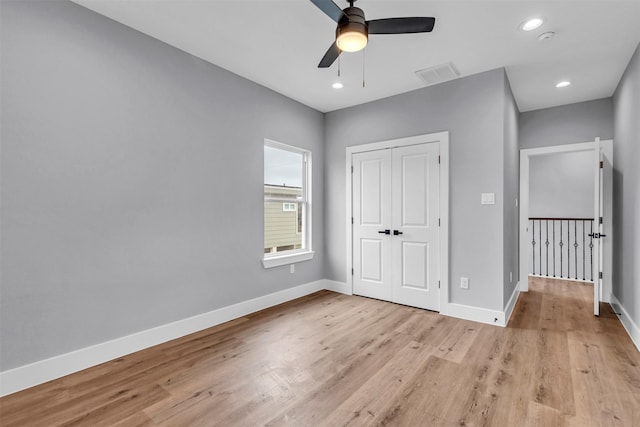 unfurnished bedroom featuring a closet, light hardwood / wood-style floors, and ceiling fan