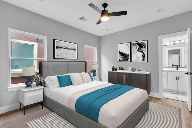 bedroom with ensuite bath, ceiling fan, and light wood-type flooring