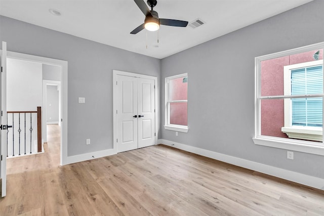 unfurnished bedroom featuring ceiling fan, light hardwood / wood-style floors, and a closet