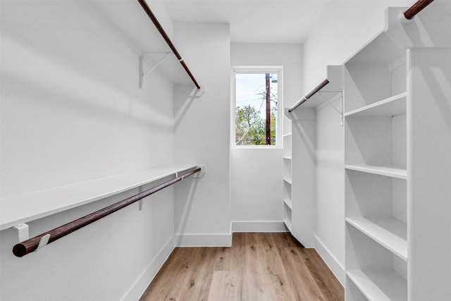 walk in closet with light hardwood / wood-style floors