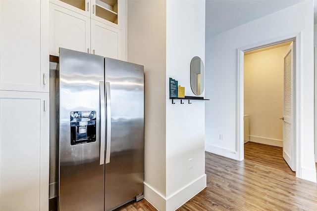 kitchen with light hardwood / wood-style floors, white cabinetry, and stainless steel fridge with ice dispenser