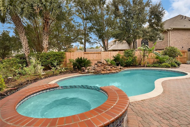 view of pool featuring an in ground hot tub