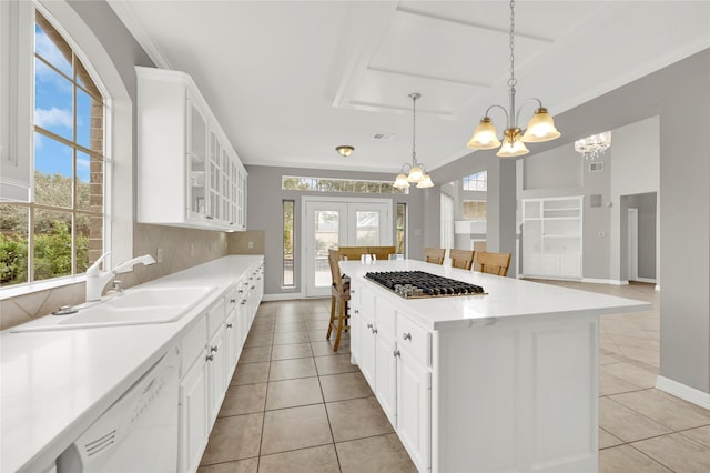 kitchen with a kitchen breakfast bar, a healthy amount of sunlight, white cabinetry, and sink