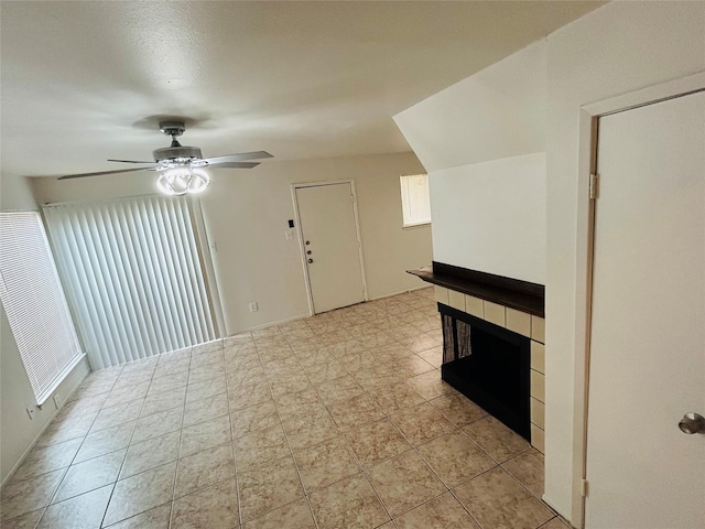 unfurnished living room featuring a multi sided fireplace and ceiling fan