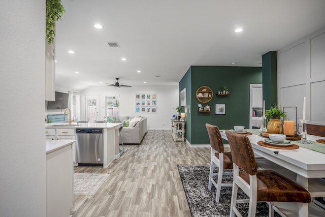 dining space with ceiling fan, sink, and light wood-type flooring