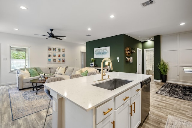 kitchen featuring dishwasher, light hardwood / wood-style flooring, white cabinetry, and sink