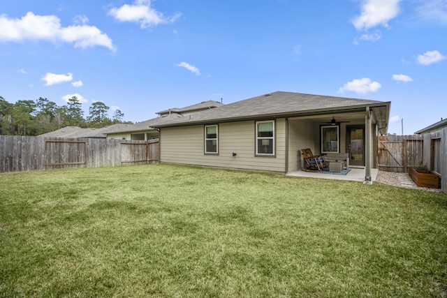 rear view of house featuring ceiling fan, a yard, and a patio