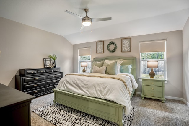 carpeted bedroom featuring vaulted ceiling, multiple windows, and ceiling fan