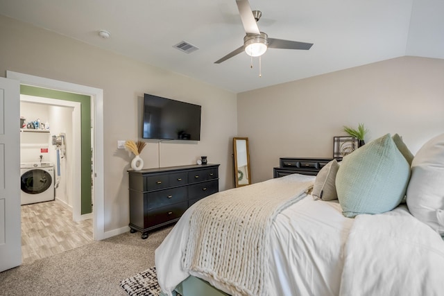 carpeted bedroom with washer / dryer, vaulted ceiling, and ceiling fan